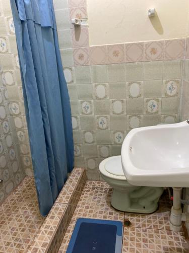 伊基托斯Casa Mafaldo的浴室设有卫生间和蓝色的浴帘。
