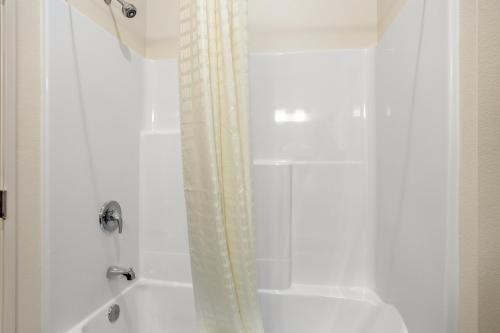 De PereCobblestone Hotel & Suites - De Pere Green Bay的带淋浴和浴帘的浴室