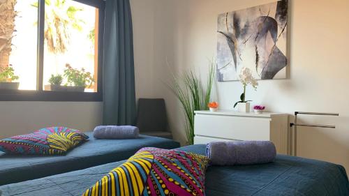 科拉雷侯Bedroom with shared bathroom and swimming pool的一间卧室设有2张蓝色的床和2个窗户。