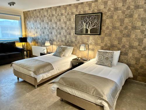 蓬塔阿雷纳斯Patagonia Apart Hotel - Suite的酒店客房,设有两张床和一张沙发