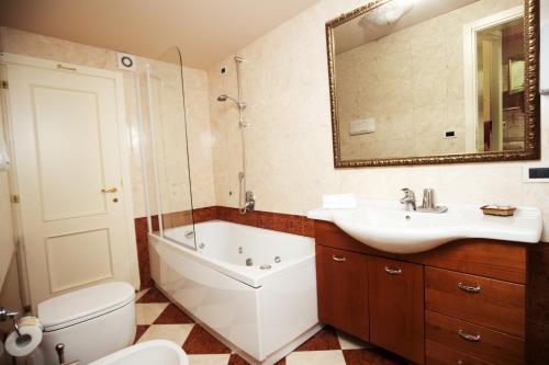 威尼斯奥多尼公寓式酒店的带浴缸、盥洗盆和卫生间的浴室