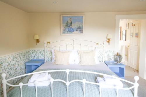 BamptonFleur de Lys Bampton的一间卧室配有一张白色的床和两个蓝色的橱柜。
