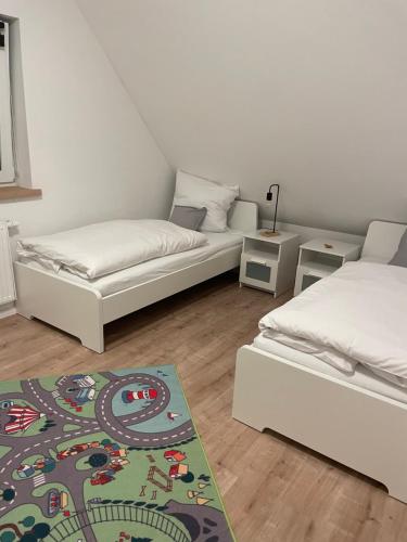 施内沃丁根Ferienwohnung Wintermoor的一间设有两张床的房间和一张地毯