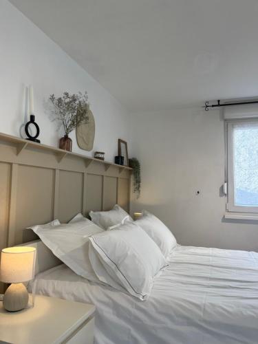 泰昂维Appartement T1 Côté jardin à Thionville的卧室配有白色的床铺和白色的枕头