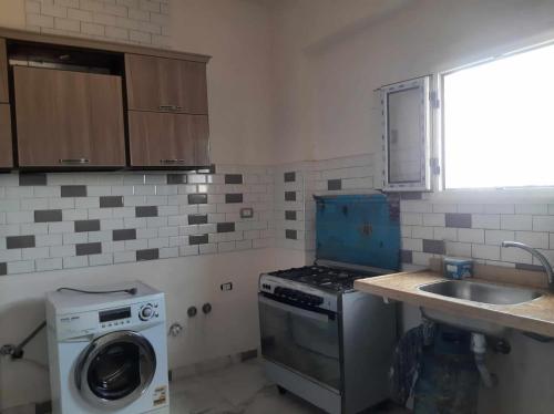 Naj‘ al Aḩwālفيلا محمد بدر的厨房配有洗衣机和水槽