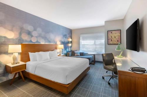 埃尔塞贡多Cambria Hotel LAX的配有一张床和一张书桌的酒店客房
