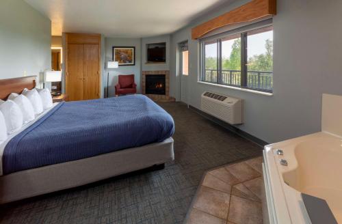 Silver BayBlack Beach Inn by GrandStay的酒店客房配有一张床和一个壁炉。