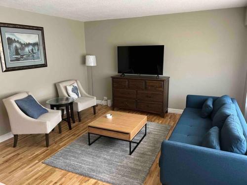 伯纳比Cozy Capitol Hill Bungalow - 3BD/2BA Retreat的客厅配有蓝色的沙发和电视
