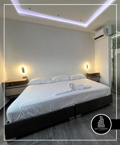 库库塔Sky Towers的一间卧室配有一张带灯的白色大床