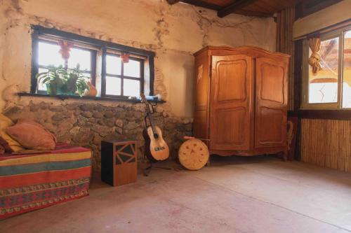 圣马科斯塞拉Espacio Circular的卧室配有吉他,旁边是橱柜和耳机