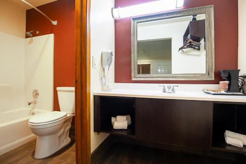 金曼Baymont by Wyndham Kingman的一间带卫生间、水槽和镜子的浴室