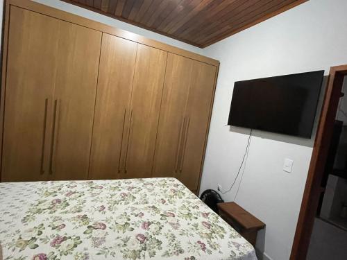 蒂拉登特斯Casa Almeida的一间卧室配有一张床和一台平面电视