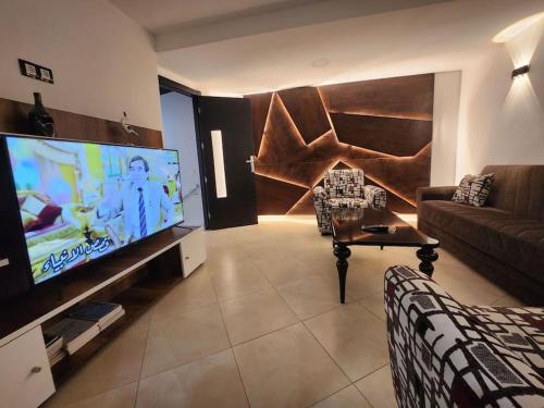 得土安Appartement Idéal : Proximité, Confort et Élégance的带沙发和大屏幕平面电视的客厅