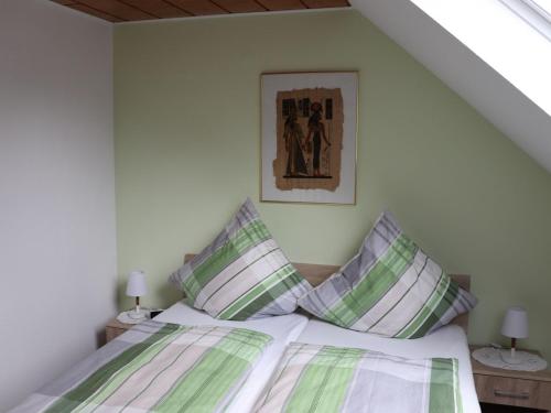 伦讷施塔特Fewo-rosenberger-sauerland的一间卧室配有带绿色和白色枕头的床
