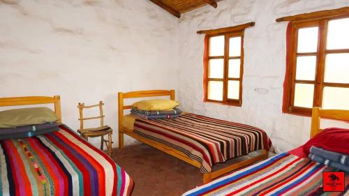 Estancia ChaunacaSamary -wasi maragua的带2扇窗户的客房内的2张床