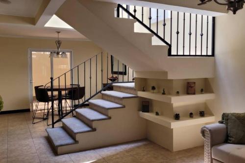 克萨尔特南戈Casa en condominio的客厅里的楼梯,配有桌子