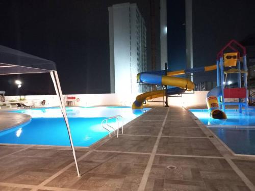 伊瓦格Hermoso apartamento con piscina ubicado cerca a los principales centros comerciales的游泳池在晚上,有滑梯