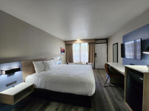 拉斐特Smart Stay Lafayette的配有一张床和一张书桌的酒店客房