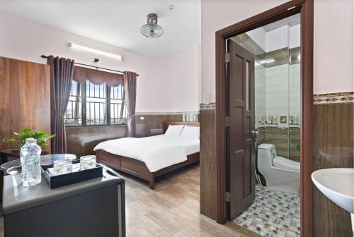 岘港Mộc Nhiên Hotel Da Nang的一间卧室配有一张床,浴室设有水槽
