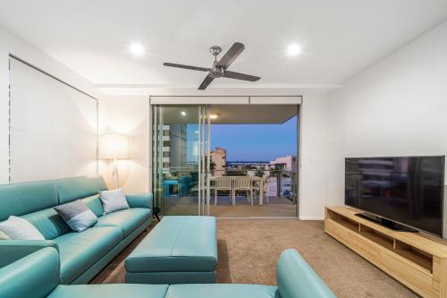 玛志洛305 Verve on Cotton Tree的客厅配有蓝色的沙发和平面电视。