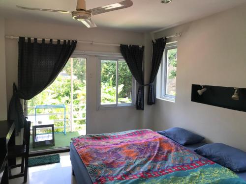 拉迈Private Lodge Beachside Samui Lamai的一间卧室设有一张床和两个窗户。