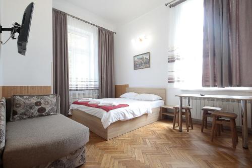 利沃夫Deluxe Apartments on Doroshenka 29的卧室配有床、椅子和窗户。