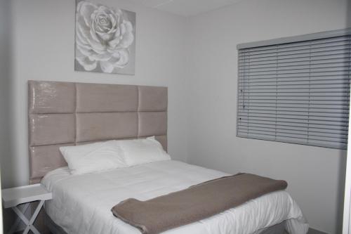 SandtonStylish Apartment in Fourways的白色客房的一张床位,设有窗户