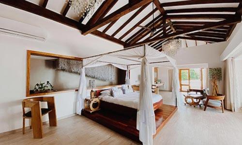 MangochiThe Makokola Retreat的一间卧室配有一张带雨伞的床