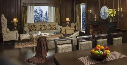 古尔马尔格凯伯尔喜马拉雅Spa度假酒店的客厅配有带一碗水果的桌子