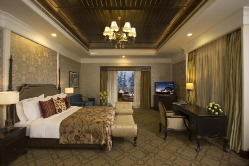 古尔马尔格凯伯尔喜马拉雅Spa度假酒店的酒店客房带一张床铺、一张书桌和一间卧室
