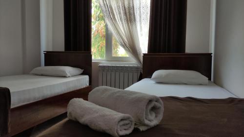 乌尔根奇Safiya hotel的卧室配有两张床和毛巾,位于地板上