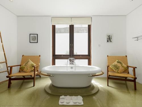 塞米亚克卡萨爱法里撒别墅的带浴缸和两把椅子的房间