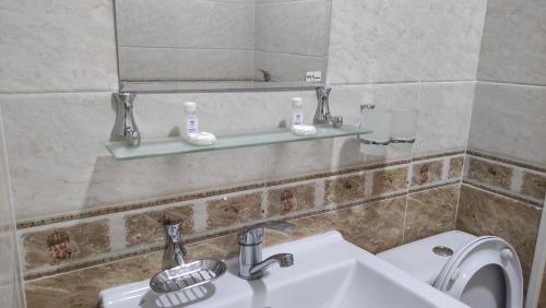 乌尔根奇Safiya hotel的一间带水槽、卫生间和镜子的浴室