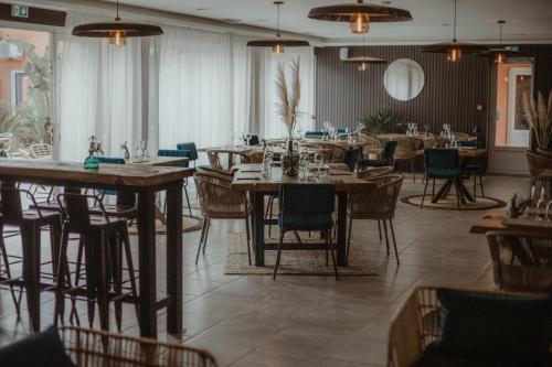滨海阿热莱斯Résidence Antinéa的一间在房间内配有桌椅的餐厅