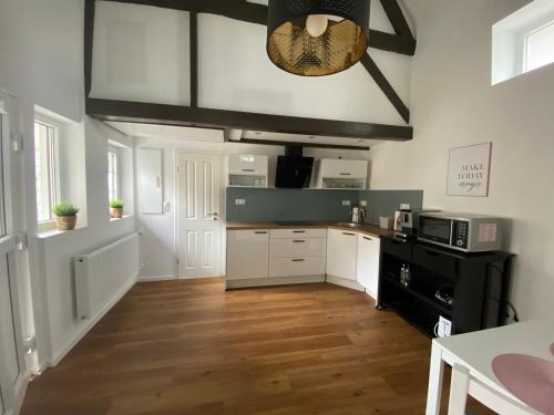 博恩海姆Scheunentraum Brenig的厨房铺有木地板,配有白色橱柜。