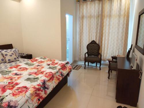 布尔班Bhurban Continental Apartment 45-F的一间卧室配有一张床、一张桌子和一把椅子
