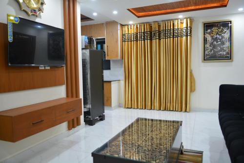 拉合尔Luxury Apartment in Bahria Town, Lahore的客厅配有平面电视和沙发。