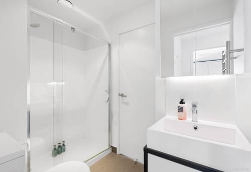 奥克兰Apartment with Brilliant views in Auckland CBD的带淋浴和盥洗盆的白色浴室