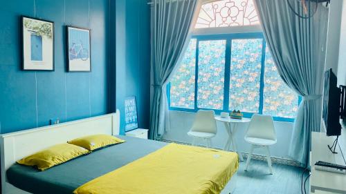 下龙湾La Casa Homestay - 11B Anh Đào, Bãi Cháy的蓝色卧室配有床、桌子和椅子