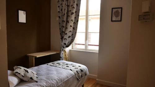 勒哈斯Relais des Monts du Lyonnais的一间小卧室,配有床和窗户