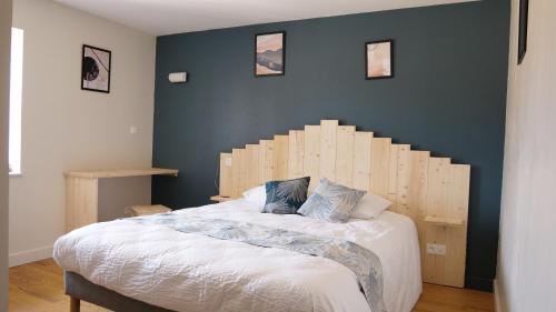 勒哈斯Relais des Monts du Lyonnais的一间卧室配有一张大床和木制床头板