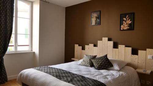 勒哈斯Relais des Monts du Lyonnais的一间卧室配有一张大床和木制床头板