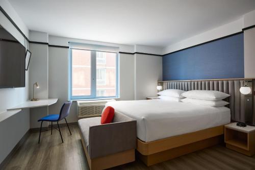 纽约Delta Hotels by Marriott New York Times Square的一间卧室配有一张床、一张桌子和一把椅子