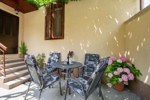 斯普利特Antique Garden Villa的庭院配有桌椅和鲜花