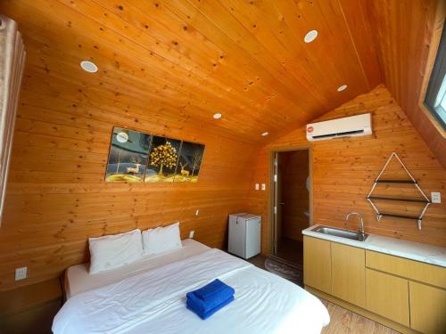 嘎那角Tân Thành Resort的木制客房内的一间卧室,配有一张床