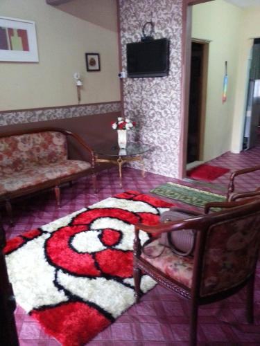 小笨珍Homestay Sri Perhentian Pontian的一间客厅,地板上铺有地毯