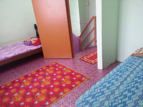 小笨珍Homestay Sri Perhentian Pontian的一间设有两张床、一扇门和地毯的房间