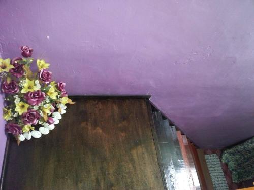 小笨珍Homestay Sri Perhentian Pontian的门上带插花的紫色天花板