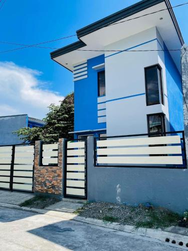 伊洛伊洛Marc louie estiaga home for rent的蓝白色的房屋,设有围栏