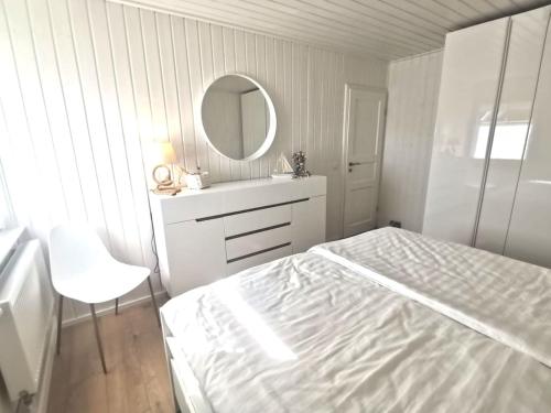 万德利茨Hafenhaus Panoramablick mit Sauna & Whirlpool的白色卧室配有床和镜子